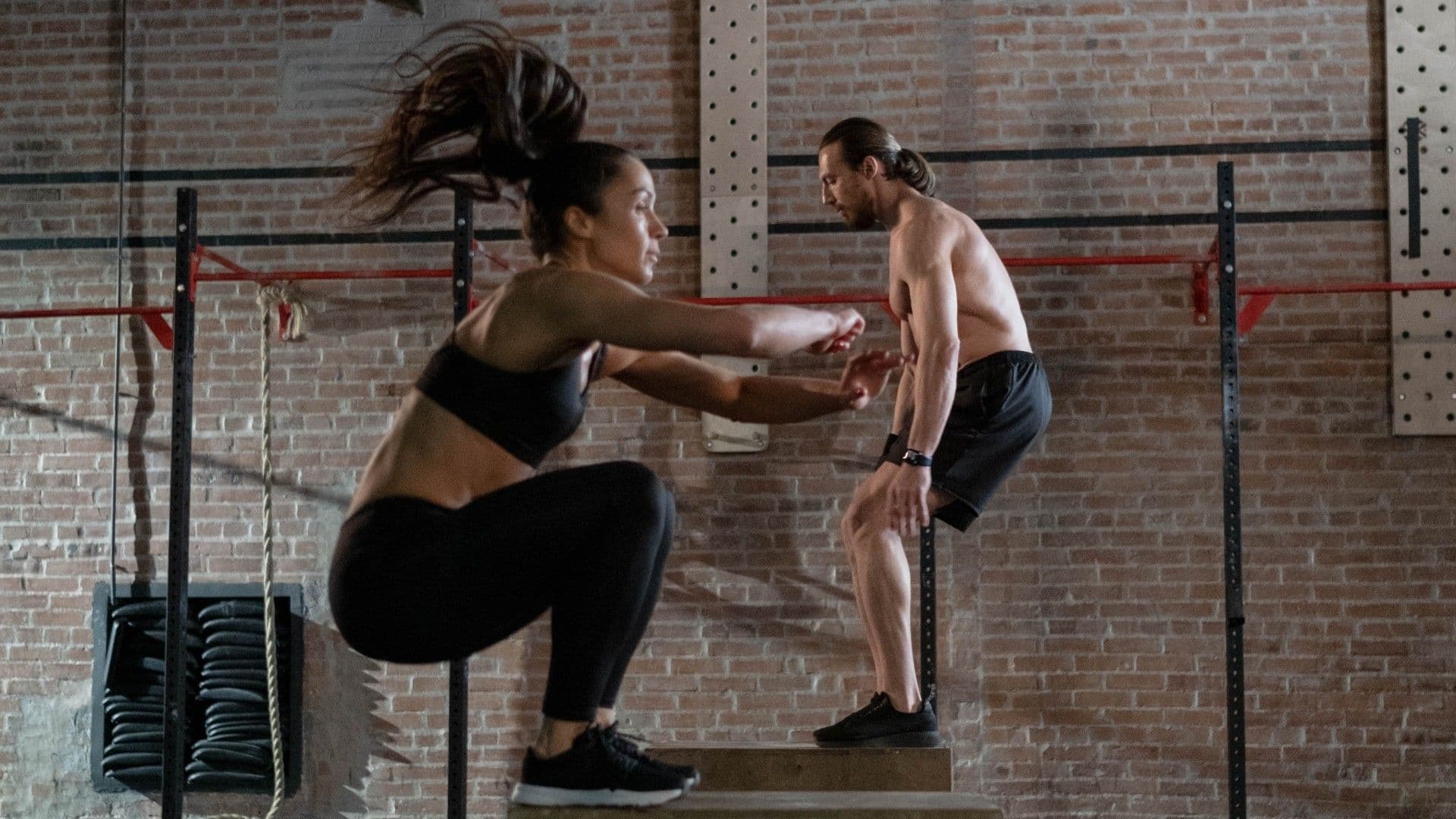 Athletes jumping on box in gym workout